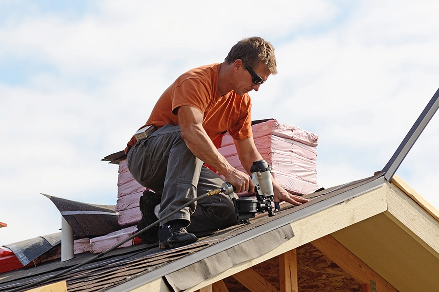 A professional male roofer repairs a leaky roof on a residential home in Pana, IL.