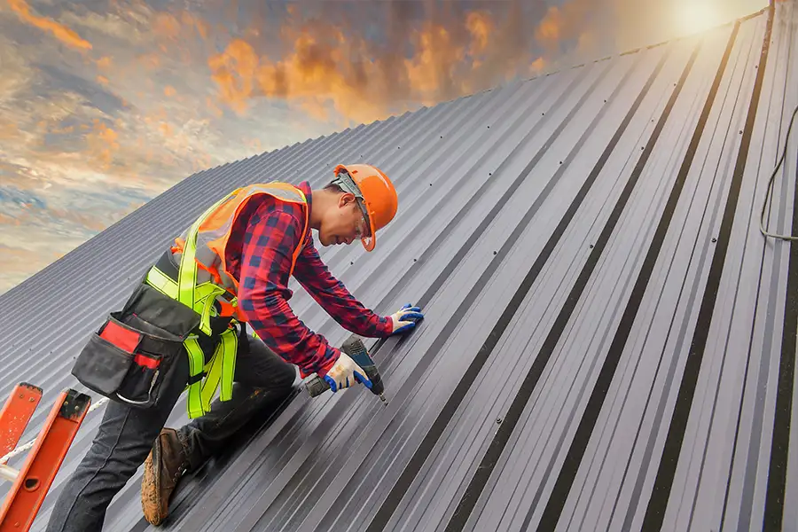 Roofer installing a metal roof on the home of a Central, IL resident's home.