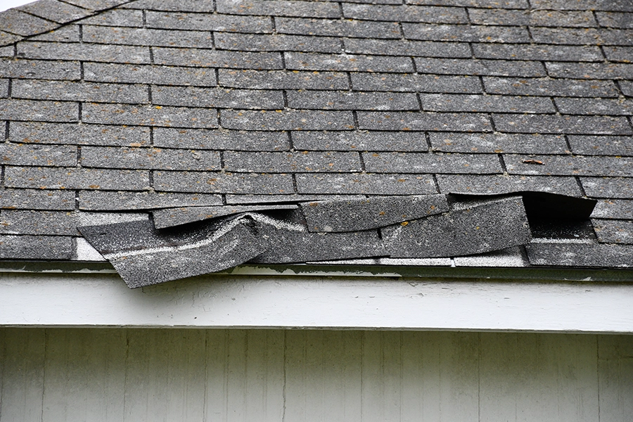 Close-up picture of wind damage to shingles on the roof of a home in Central IL.