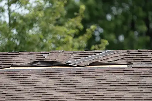 At Your Service Roofing – A roof on a home in Pana, IL, with torn shingles caused by storm damage.