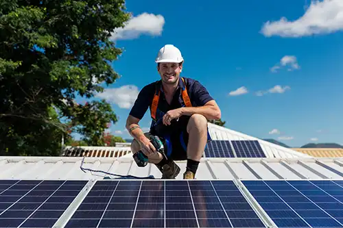 A professional roofing technician with a drill installs solar panels to a home in Springfield, IL.