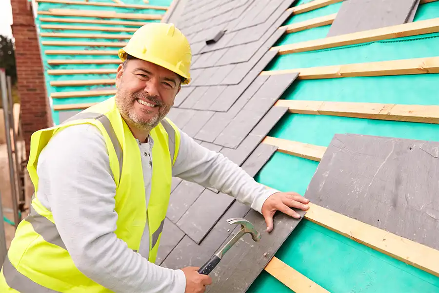 At Your Service Roofing—A professional roofer laying slate tiles on a property in Shelbyville, IL.