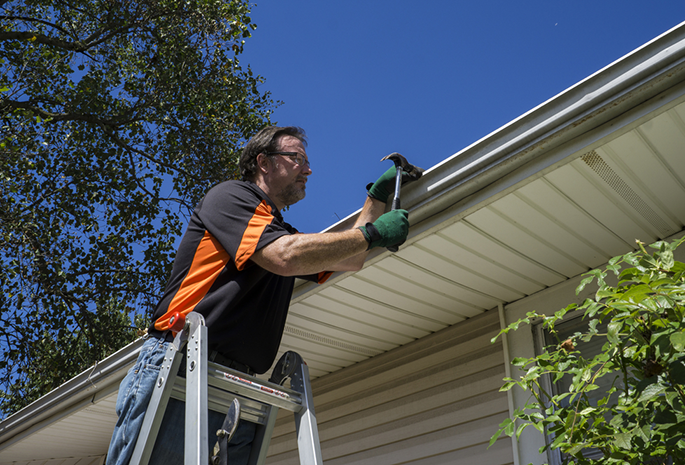 worker repairing gutter for residential house in central il