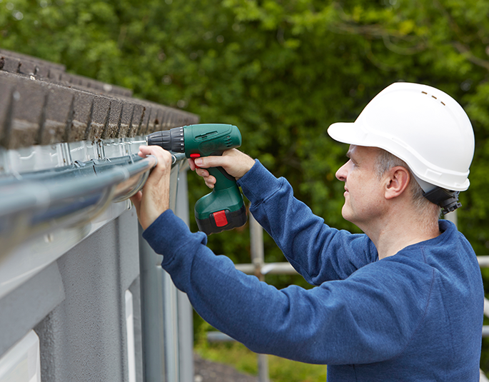 worker repairing gutter for residential house in central illinois