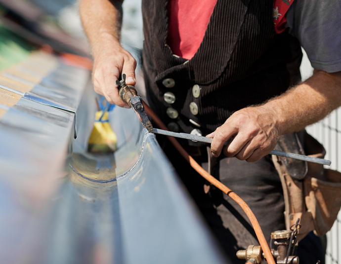 worker repairing gutter on house in central il