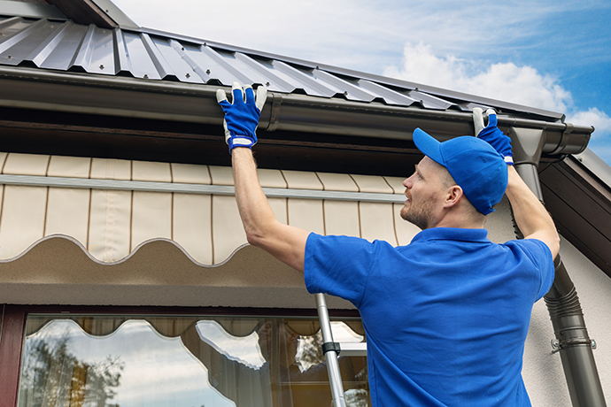 man installing house roof rain gutter system central il