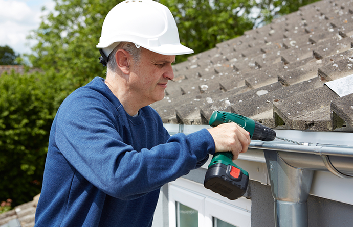 worker repairing gutter for residential house in central illinois