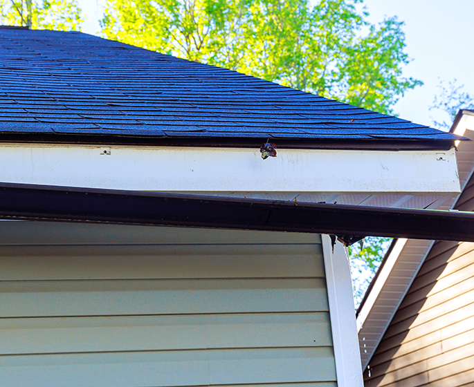 Broken rain gutter on roof of house after storm central il