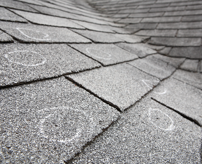 Old roof with hail damaged shingles, chalk circles mark the damage central illinois