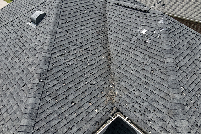 Severe hail damage on asphalt shingle roof after storm central illinois