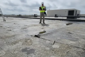 At Your Service Roofing—An adjuster assessing storm damage on a flat commercial roof in Pana, IL.